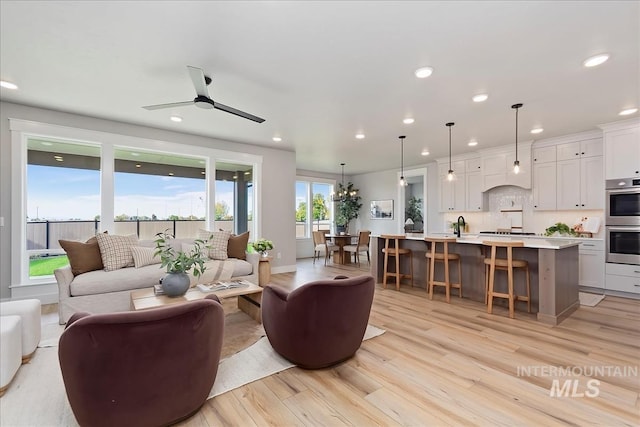 4716 N Camp Creek Ave, Meridian, ID 83646 - living area with light wood-type flooring, recessed lighting, and ceiling fan with notable chandelier