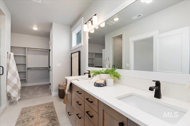 4716 N Camp Creek Ave, Meridian, ID 83646 - bathroom featuring a sink, a stall shower, visible vents, double vanity, and a spacious closet