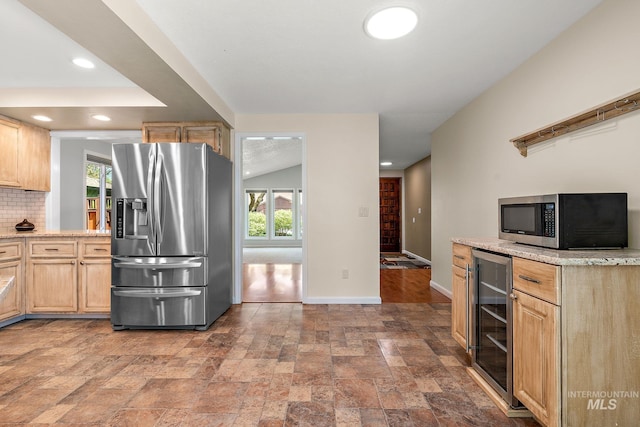 kitchen featuring light brown cabinets, plenty of natural light, stainless steel appliances, and beverage cooler