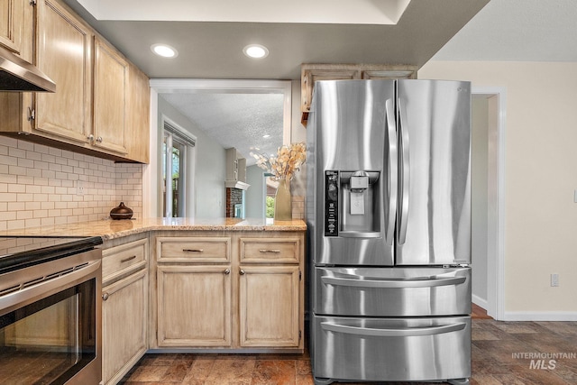 kitchen with baseboards, stone finish floor, light countertops, tasteful backsplash, and appliances with stainless steel finishes