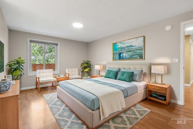 bedroom with baseboards and light wood-style flooring