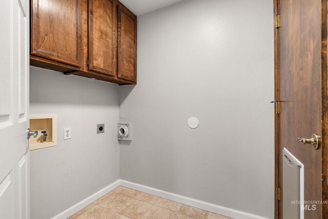 laundry area featuring hookup for an electric dryer, cabinet space, baseboards, hookup for a washing machine, and light tile patterned flooring