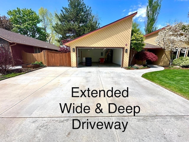 garage featuring fence and driveway