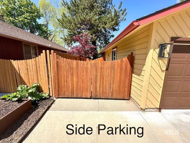 view of side of property featuring fence and a garage