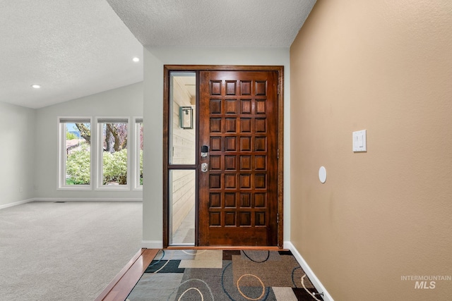 carpeted foyer entrance featuring recessed lighting, a textured ceiling, vaulted ceiling, and baseboards