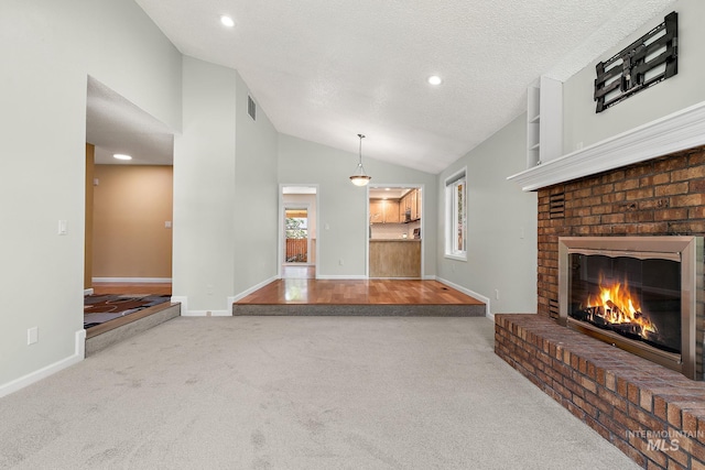 unfurnished living room featuring visible vents, lofted ceiling, a fireplace, baseboards, and carpet flooring