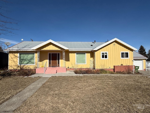 ranch-style house featuring a garage, metal roof, and board and batten siding