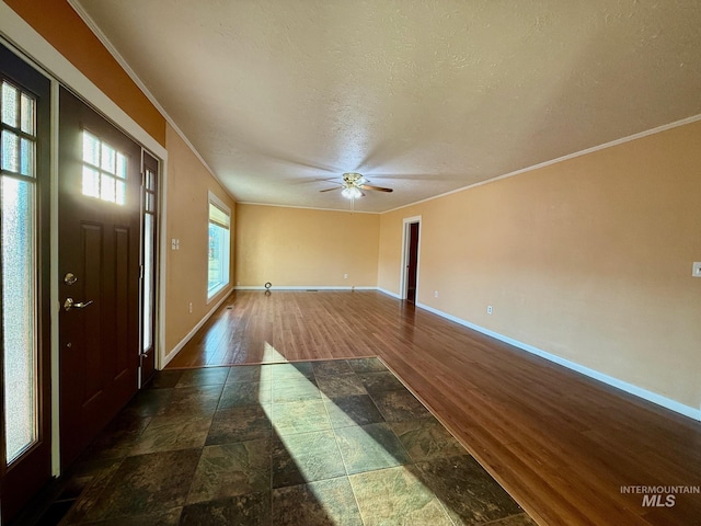 entrance foyer with ornamental molding, ceiling fan, a textured ceiling, wood finished floors, and baseboards