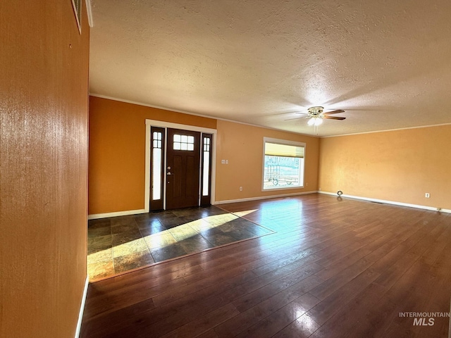 foyer entrance with ceiling fan, a textured ceiling, wood-type flooring, and baseboards