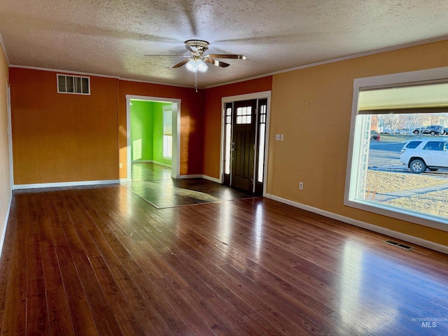 interior space with hardwood / wood-style flooring, visible vents, and crown molding