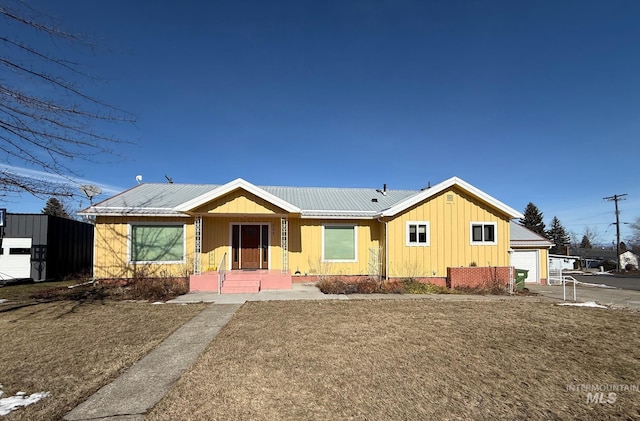 view of front of home featuring an attached garage, driveway, metal roof, and board and batten siding