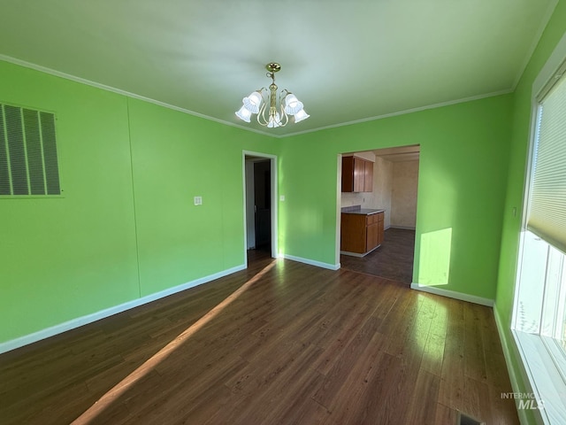 unfurnished room with dark wood-style floors, crown molding, visible vents, a chandelier, and baseboards