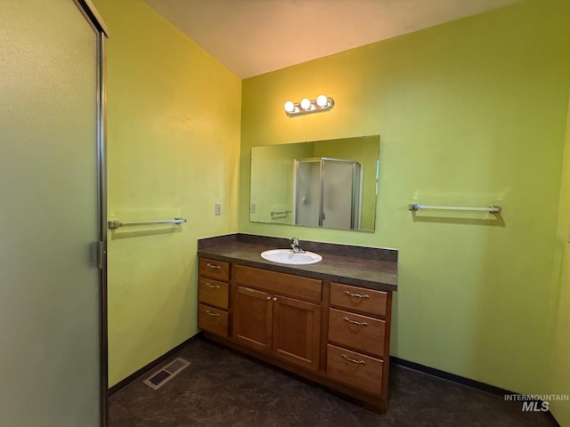 full bath with a shower with shower door, visible vents, vanity, and baseboards