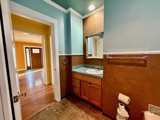 bathroom featuring wainscoting, ornamental molding, and vanity