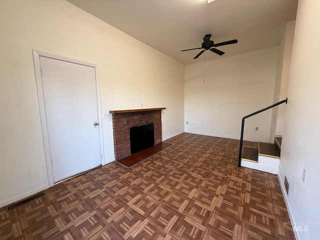 unfurnished living room with visible vents, a fireplace, and ceiling fan