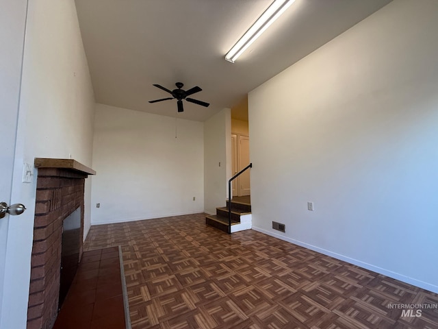 unfurnished living room with a fireplace, visible vents, baseboards, a ceiling fan, and stairway