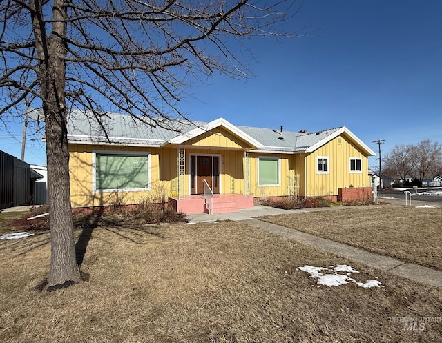 ranch-style house featuring metal roof and board and batten siding