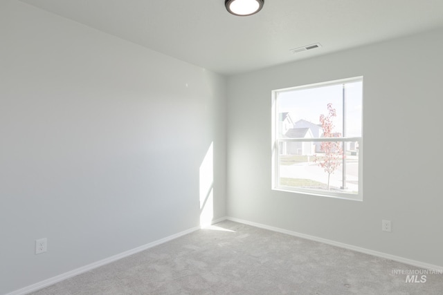 spare room featuring baseboards, visible vents, and carpet floors