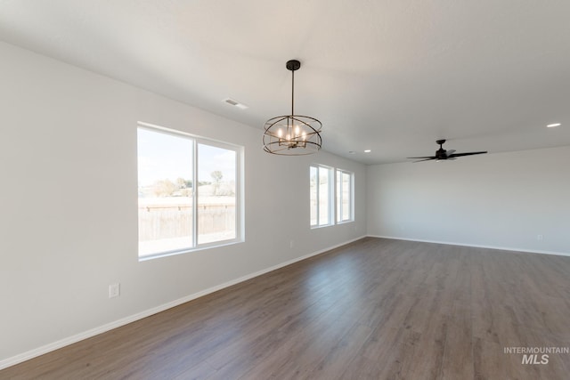 unfurnished room with visible vents, baseboards, recessed lighting, ceiling fan with notable chandelier, and wood finished floors