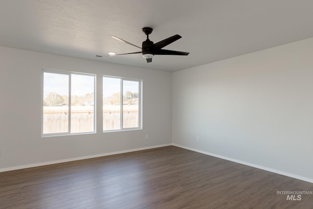 empty room with baseboards, a textured ceiling, ceiling fan, and dark wood-style flooring