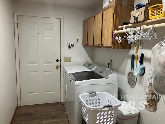 laundry area with dark wood-style floors, cabinet space, and washer and clothes dryer