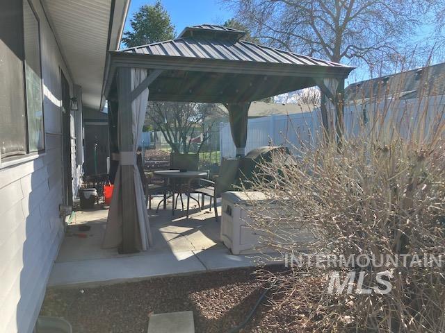 view of patio / terrace featuring a gazebo, outdoor dining space, and fence