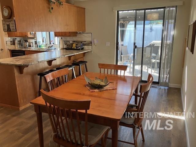 dining space featuring dark wood finished floors and baseboards