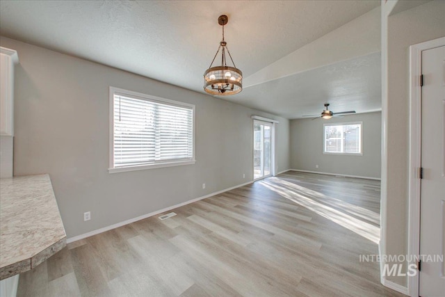 10683 W Capella St, Star, ID 83669 - unfurnished dining area featuring ceiling fan with notable chandelier, light hardwood / wood-style floors, and lofted ceiling