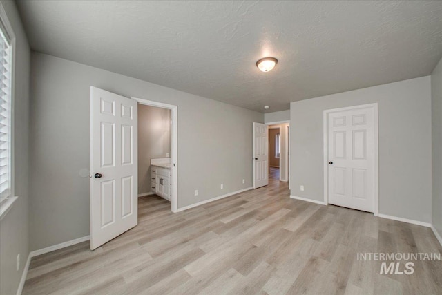 10683 W Capella St, Star, ID 83669 - unfurnished bedroom featuring ensuite bathroom, light hardwood / wood-style flooring, and a textured ceiling