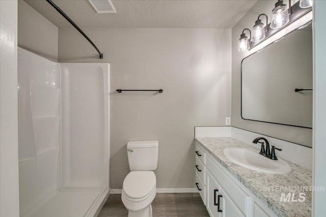 10683 W Capella St, Star, ID 83669 - bathroom with a textured ceiling, toilet, walk in shower, and vanity