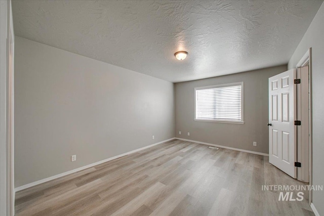10683 W Capella St, Star, ID 83669 - unfurnished bedroom featuring a textured ceiling and light hardwood / wood-style flooring