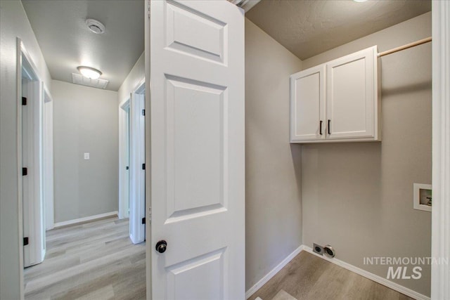 10683 W Capella St, Star, ID 83669 - laundry area featuring a textured ceiling, cabinets, washer hookup, and light wood-type flooring
