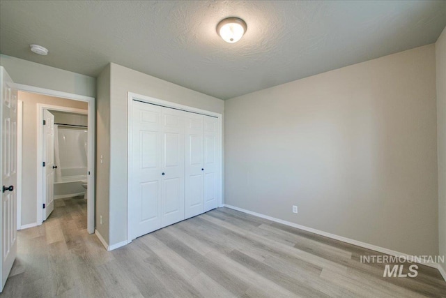 10683 W Capella St, Star, ID 83669 - unfurnished bedroom featuring light wood-type flooring, a textured ceiling, and a closet