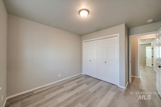 10683 W Capella St, Star, ID 83669 - unfurnished bedroom with a closet, light hardwood / wood-style floors, and a textured ceiling