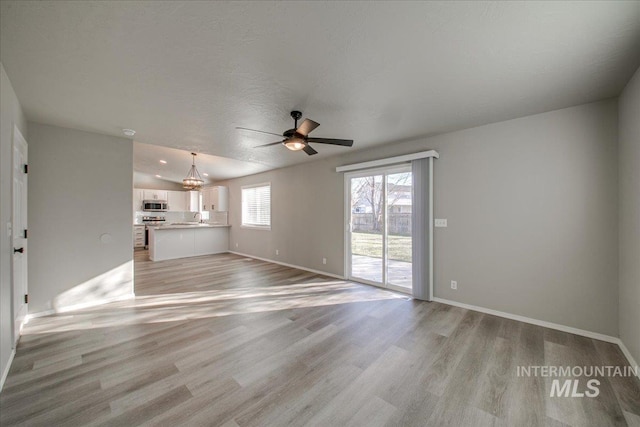 10683 W Capella St, Star, ID 83669 - unfurnished living room featuring light hardwood / wood-style floors, a textured ceiling, sink, ceiling fan, and lofted ceiling
