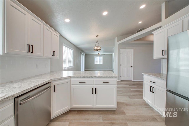 10683 W Capella St, Star, ID 83669 - kitchen with white cabinetry, stainless steel appliances, and vaulted ceiling