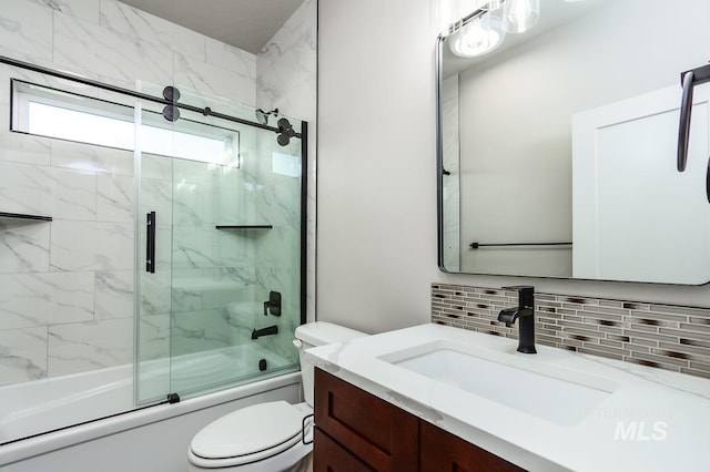 full bathroom featuring vanity, toilet, combined bath / shower with glass door, and tasteful backsplash