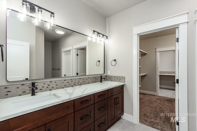 bathroom featuring tile patterned flooring, decorative backsplash, and vanity