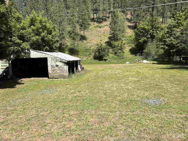 187 Harmony Heights Loop, Orofino, ID 83544 - view of green lawn featuring an outdoor structure, a pole building, and a view of trees