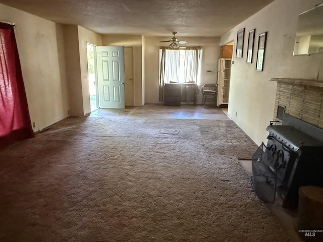 187 Harmony Heights Loop, Orofino, ID 83544 - unfurnished living room with carpet flooring, a ceiling fan, and a wood stove