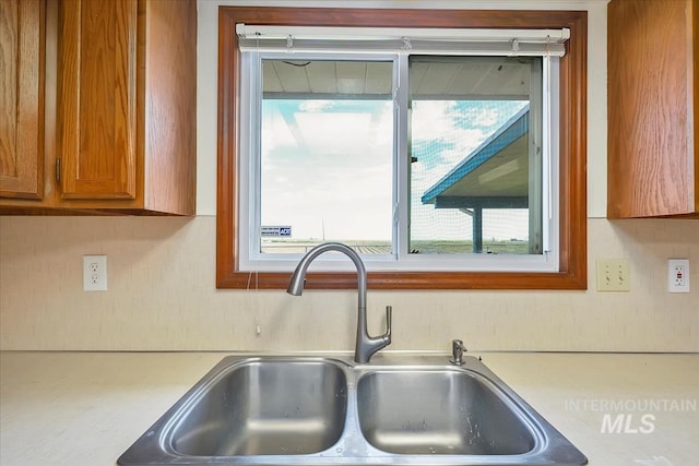 16476 Ustick Rd, Caldwell, ID 83607 - kitchen view of a sink, light countertops, and brown cabinetry