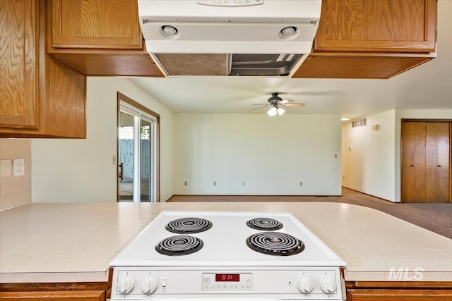 16476 Ustick Rd, Caldwell, ID 83607 - kitchen with range, under cabinet range hood, light countertops, ceiling fan, and brown cabinetry