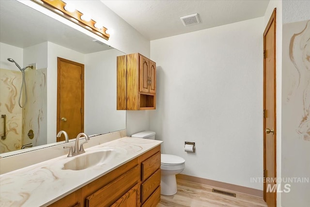 16476 Ustick Rd, Caldwell, ID 83607 - bathroom featuring toilet, vanity, wood finished floors, a shower, and baseboards