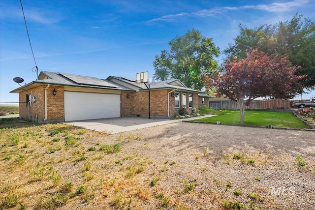 16476 Ustick Rd, Caldwell, ID 83607 - view of home's exterior with brick siding, roof mounted solar panels, and a garage