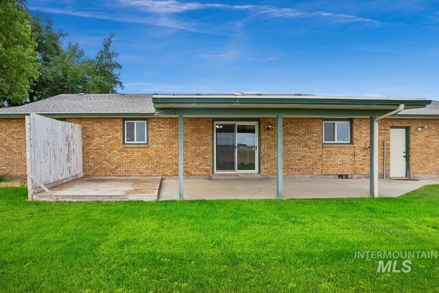 16476 Ustick Rd, Caldwell, ID 83607 - back of house with a patio, a lawn, and brick siding