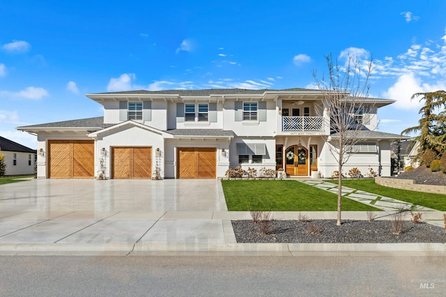 view of front facade with a front lawn, a balcony, driveway, and stucco siding