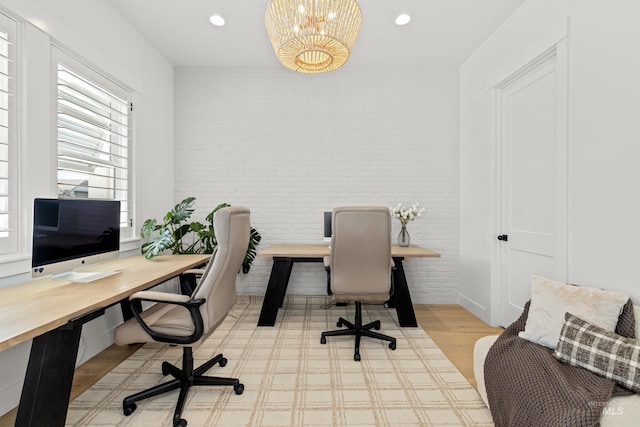 office space with recessed lighting, brick wall, and an inviting chandelier