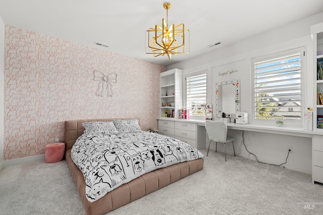 carpeted bedroom with visible vents, baseboards, built in desk, and wallpapered walls