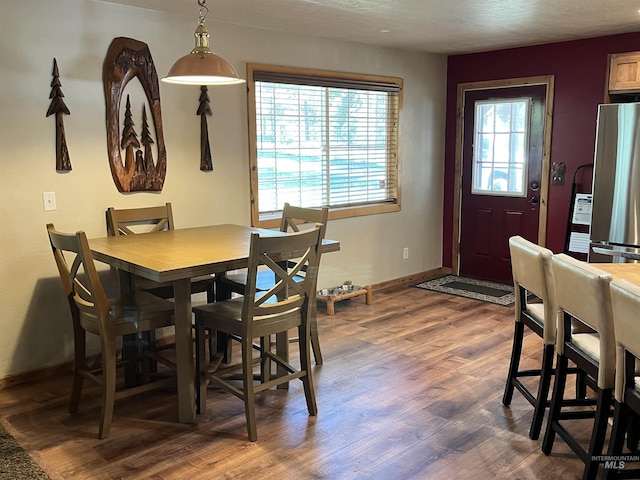 dining area with dark wood-style flooring and baseboards