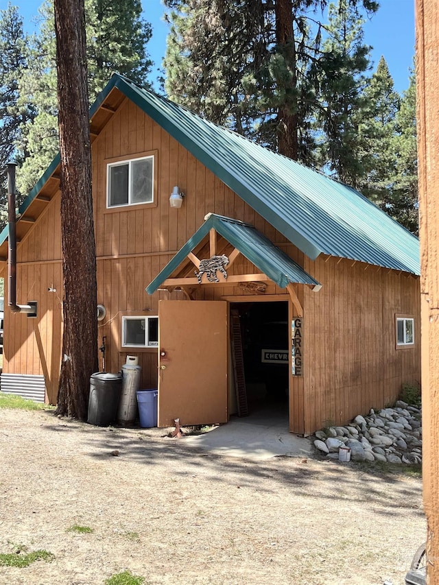 exterior space featuring an outbuilding and metal roof